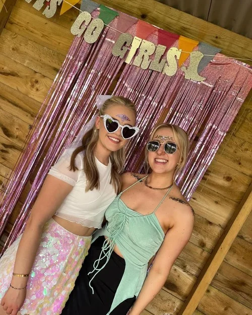 Two friends with sunglasses at a hen party photo backdrop