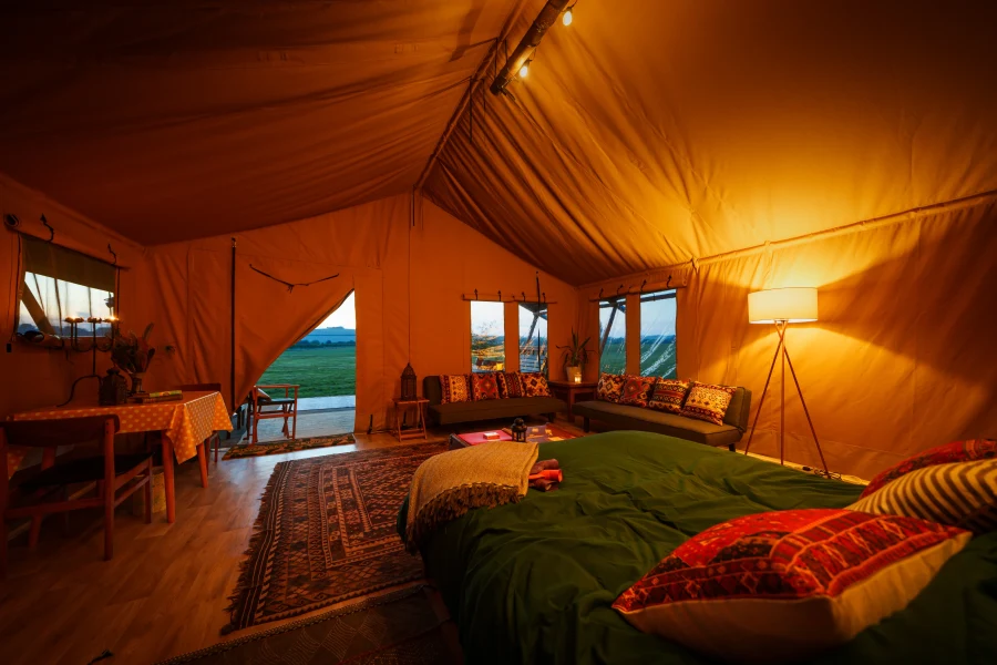 Interior safari tent with view from bed and open door looking out at Chalke Valley