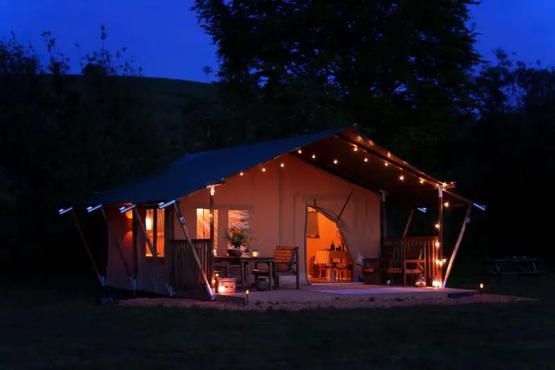 Safari tent exterior with fairy lights at Chalke Valley Camping